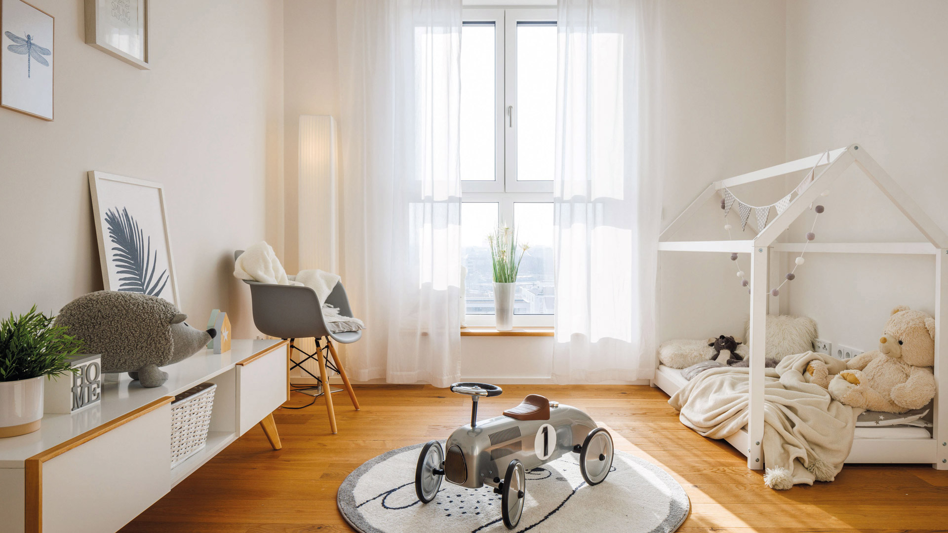 KI-basierte Bildbeschreibung: Ein Kinderzimmer mit einem Spielzeugauto auf einem Teppich.